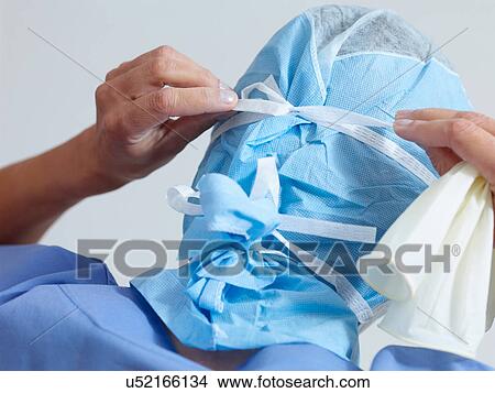 Picture - Surgeon putting on surgical mask. Fotosearch