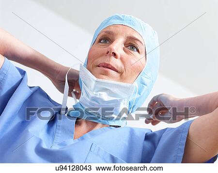 Stock Image - Surgeon putting on surgical mask. Fotosearch