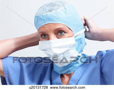 Stock Photo - Surgeon putting on surgical mask. Fotosearch