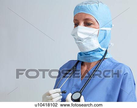 Stock Image - Surgeon wearing surgical scrubs and mask. Fotosearch