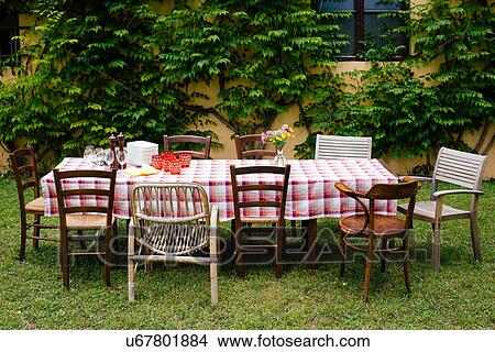 Table and chairs in garden ready for family meal View Large Photo Image Picture - Table and chairs in garden ready for family meal. Fotosearch