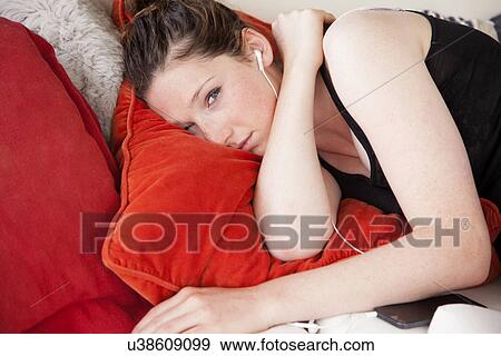 Teenager lying on bed listening to music View Large Photo Image Stock Photo - Teenager lying on bed listening to music. Fotosearch