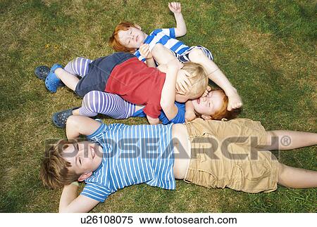 Three brothers and sister lying on grass in garden View Large Photo Image Stock Photography - Three brothers and sister lying on grass in garden. Fotosearch