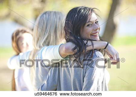 Three young women strolling in park View Large Photo Image Stock Photograph - Three young women strolling in park. Fotosearch