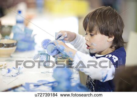 Picture - Toddler concentrating in art class. Fotosearch