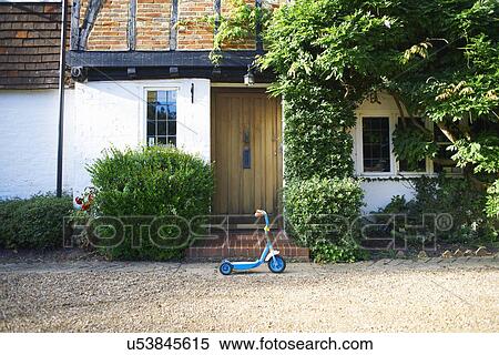 Toy scooter parked outside cottage View Large Photo Image Stock Photography - Toy scooter parked outside cottage. Fotosearch