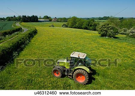 Tractor working in green fields View Large Photo Image Stock Image - Tractor working in green fields. Fotosearch