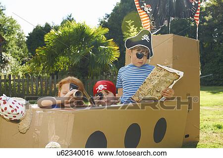 Two brothers and sister playing with homemade pirate ship in garden View Large Photo Image Stock Photograph - Two brothers and sister playing with homemade pirate ship in garden. Fotosearch