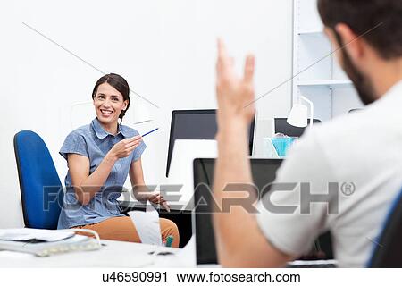 Two colleagues talking in office View Large Photo Image Stock Image - Two colleagues talking in office. Fotosearch