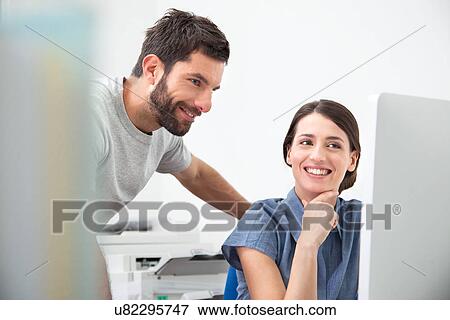Stock Photo - Two colleagues using computer. Fotosearch