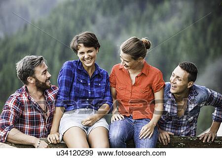 Two couple sitting on fence, Tyrol Austria View Large Photo Image Stock Photo - Two couple sitting on fence, Tyrol Austria. Fotosearch