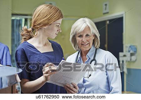 Two female doctors checking medical record View Large Photo Image Stock Image - Two female doctors checking medical record. Fotosearch