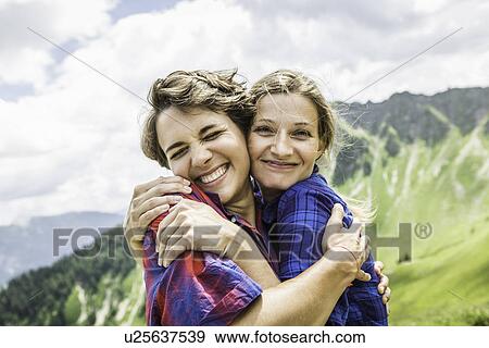 Stock Photo - Two female friends hugging, Tyrol, Austria. Fotosearch