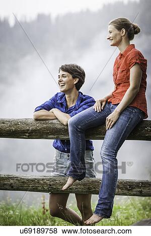 Two female friends looking at view, Tyrol Austria View Large Photo Image Stock Photo - Two female friends looking at view, Tyrol Austria. Fotosearch