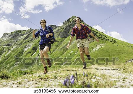 Two female friends running, Tyrol, Austria View Large Photo Image Stock Photograph - Two female friends running, Tyrol, Austria. Fotosearch