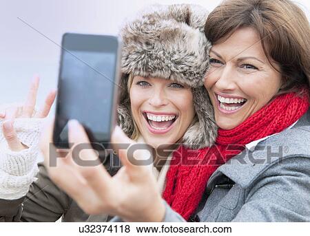 Two female friends taking self portrait at coast, Thurlestone, Devon, UK View Large Photo Image Stock Photo - Two female friends taking self portrait at coast, Thurlestone, Devon, UK. Fotosearch