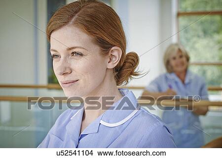 Two female nurses on hospital atrium balcony View Large Photo Image Picture - Two female nurses on hospital atrium balcony. Fotosearch