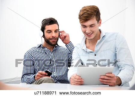 Stock Image - Two male colleagues using digital tablet. Fotosearch