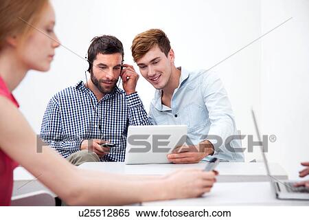 Two male colleagues using digital tablet View Large Photo Image Stock Photography - Two male colleagues using digital tablet. Fotosearch