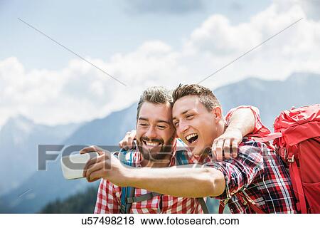 Two male friends photographing themselves, Tyrol, Austria View Large Photo Image Stock Photo - Two male friends photographing themselves, Tyrol, Austria. Fotosearch