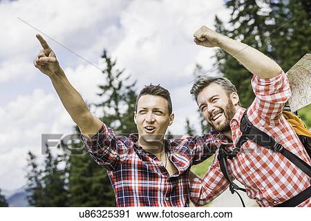 Stock Image - Two male friends pointing and cheering. Fotosearch