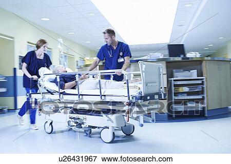 Stock Photo - Two medics rushing with gurney in hospital emergency room. Fotosearch