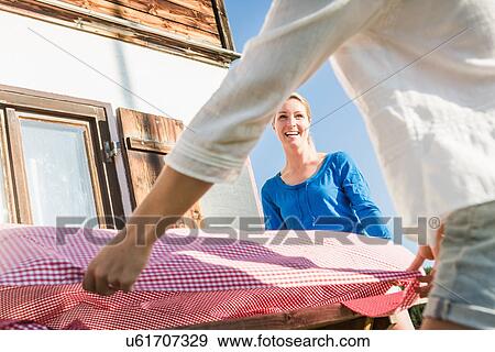 Two women preparing table outside chalet, Tyrol, Austria View Large Photo Image Stock Photo - Two women preparing table outside chalet, Tyrol, Austria. Fotosearch