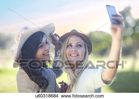 Picture - Two young women in park posing for self portrait. Fotosearch