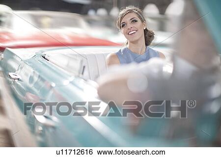 Stock Photograph - Woman enjoying ride in back seat of vintage convertible. Fotosearch