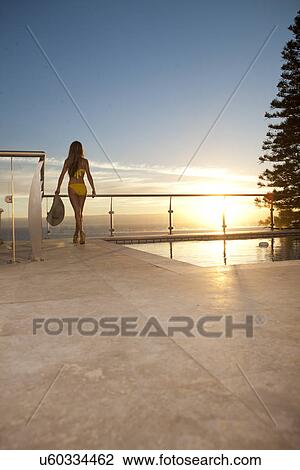 Woman enjoying sunset by swimming pool View Large Photo Image Stock Image - Woman enjoying sunset by swimming pool. Fotosearch