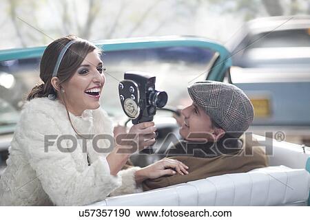 Woman in convertible with vintage hand-held video View Large Photo Image Stock Image - Woman in convertible with vintage hand-held video. Fotosearch