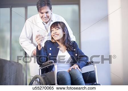 Woman in wheelchair assisted by male nurse View Large Photo Image Stock Photography - Woman in wheelchair assisted by male nurse. Fotosearch