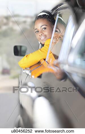 Stock Image - Woman leaning out of car window. Fotosearch