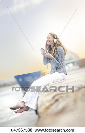 Stock Photo - Woman listening to music, Hout Bay, Cape Town, South Africa. Fotosearch