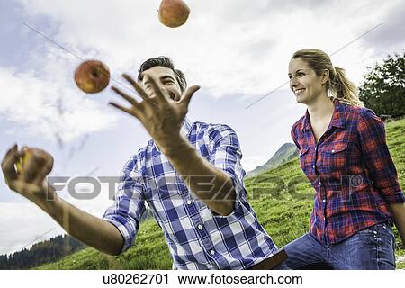 Woman looking at man juggling apples View Large Photo Image Stock Image - Woman looking at man juggling apples. Fotosearch