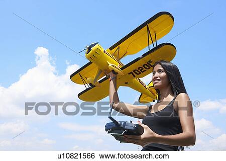 Stock Photograph - Woman preparing to launch model plane. Fotosearch