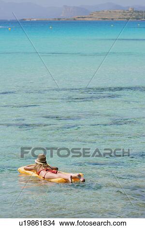 Picture - Woman relaxing on inflatable mattress, Formentera, Balearic Islands, Spain. Fotosearch