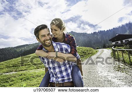 Woman riding piggyback on man, Tirol, Austria View Large Photo Image Stock Photo - Woman riding piggyback on man, Tirol, Austria. Fotosearch