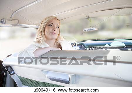 Woman sitting sideways in vintage car View Large Photo Image Stock Photograph - Woman sitting sideways in vintage car. Fotosearch
