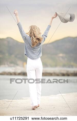 Woman stretching with hat in hand, Hout Bay, Cape Town, South Africa View Large Photo Image Stock Image - Woman stretching with hat in hand, Hout Bay, Cape Town, South Africa. Fotosearch