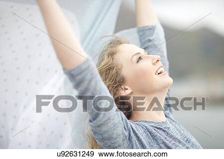 Woman stretching with scarf in hand, Hout Bay, Cape Town, South Africa View Large Photo Image Stock Photo - Woman stretching with scarf in hand, Hout Bay, Cape Town, South Africa. Fotosearch