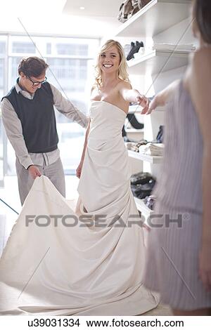 Picture - Woman trying on wedding dress. Fotosearch