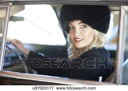 Woman with fur hat driving vintage car View Large Photo Image Stock Photo - Woman with fur hat driving vintage car. Fotosearch