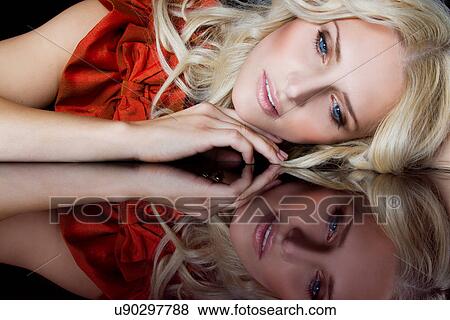 Stock Photo - Woman with reflection of herself on table. Fotosearch
