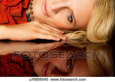 Stock Photography - Woman with reflection of herself on table. Fotosearch