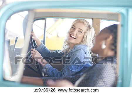 Women at wheels of vintage car laughing View Large Photo Image Stock Photograph - Women at wheels of vintage car laughing. Fotosearch