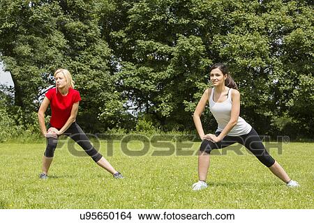 Picture - Women warming up for exercise in park. Fotosearch