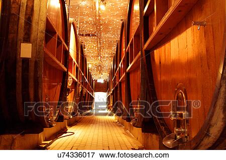 Wooden wine barrels in industrial wine cellar View Large Photo Image Stock Photo - Wooden wine barrels in industrial wine cellar. Fotosearch