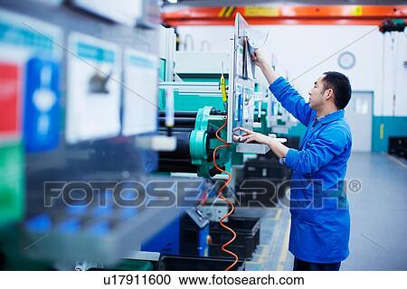 Worker at small parts manufacturing factory in China, reaching up to press button on control panel View Large Photo Image Stock Image - Worker at small parts manufacturing factory in China, reaching up to press button on control panel. Fotosearch