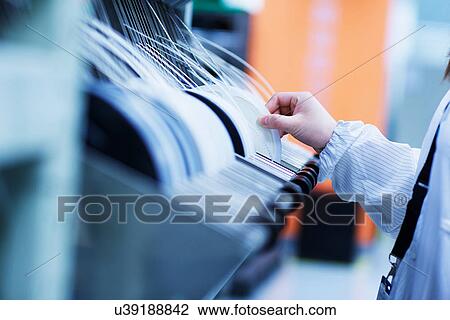 Stock Image - Worker at small parts manufacturing factory in China. Fotosearch